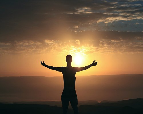 Woman meditating outdoors during sunrise